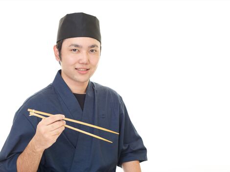 菜箸を持つスタッフ